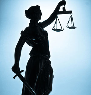 Justitia als Silhouette vor blauem Hintergrund